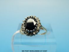 A 9ct gold ring set with a sapphire surrounded by diamonds (size K/L)