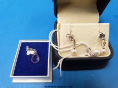 A 9ct white gold pendant set with a pearl and diamonds with matching earring together with a white
