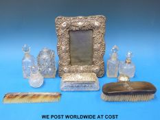 A hallmarked silver embossed photograph frame to suit a 6in x 4in photo together with a quantity of