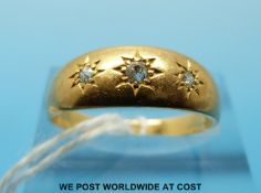 An 18ct gold ring set with three diamonds in star settings (size P)