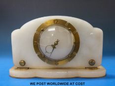 An alabaster cased mantel clock with brass dial and Art Deco moon shaped hands.