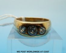 A yellow metal ring set with three round brilliant cut diamonds, the largest stone approximately 0.