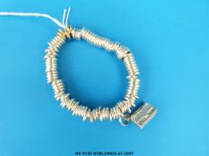 A Links of London bracelet of circular links and a purse charm