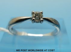 An 18ct white gold ring set with a round brilliant cut diamond measuring approximately 0.