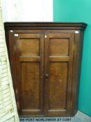 A Georgian oak corner cupboard with panelled doors (H125 x W106 x D65cm)