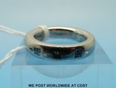 A platinum ring set with three princess cut diamonds (size J)