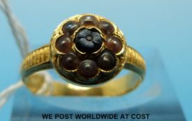 A Victorian yellow metal ring set with a flower cameo and seed pearls (size K)
