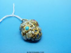 An unusual pendant formed of a baroque pearl set with turquoise, rubies,