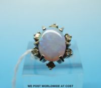 An 18ct white gold ring set with an oval opal surrounded by diamonds (size L)