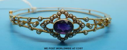 A 15ct gold bangle set with an amethyst and seed pearls
