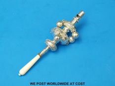A white metal and ivory-handled baby's rattle with bells and whistle (length 16cm)