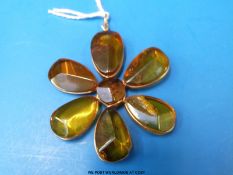 A flower pendant set with translucent amber from Colombia