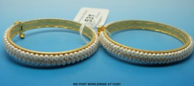 Two yellow metal bangles each set with two rows of pearls, bought from Sri Jagdamba,