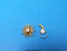 A 9ct gold pendant set with a diamond in a star burst design and a yellow metal pendant set with a