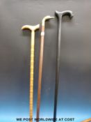 A farmer's crook in the form of a bull's head together with three other walking sticks