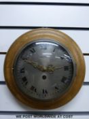A circular oak cased wall clock with Mauthe movement and pendulum