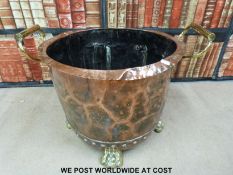 A 19thC copper bowl raised on brass lion paw feet and with brass handles (H44 x 49cm diameter)