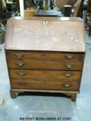 A George III oak bureau with four graduated drawers, fall flap and fitted interior,