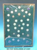 A collection of enamel and silver buttons in a frame,