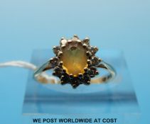 A 9ct gold ring set with an oval cut critrine/topaz surrounded by diamonds (size N)
