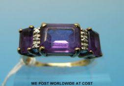 A 9ct gold ring set with three emerald cut amethysts and diamonds (size N)
