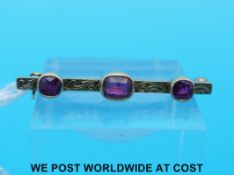 An Edwardian yellow metal brooch set with three synthetic rubies