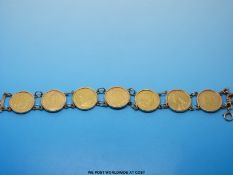 A 9ct gold bracelet set with seven half sovereigns, six with shield backs 1878, 1892, 1849, 1897,