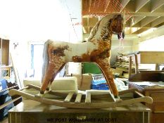 A wooden framed straw filled rocking horse on carved base,