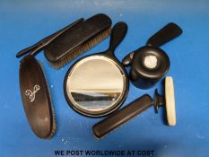 A collection of ebony dressing table items including hallmarked silver mounted example