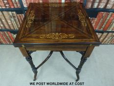 A 19thC inlaid rosewood games table with four fold out flaps, single drawer below,