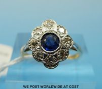 An Art Deco style 18ct gold ring set with a central sapphire surrounded by diamonds in a platinum