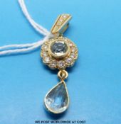 A gold pendant set with aquamarines and diamonds in a flower cluster