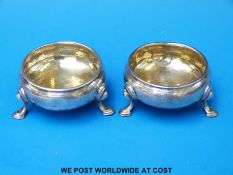 A pair of George II hallmarked silver hoof-footed salts with gilt wash interiors,