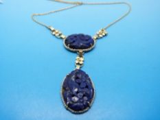 A yellow metal necklace marked 14ct gold with two carved lapis lazuli sections surrounded by seed