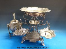 A plated Art Nouveau epergne style serving stand with three hanging dishes and a plated spirit