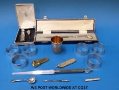 A set of six white metal napkin rings marked 