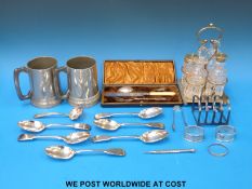 A cased pierced presentation cutlery set, toast rack, cruet, two pewter mugs with glass bottoms,