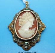 An unusual pendant /brooch with a cameo set to the centre surrounded by two emeralds and diamonds