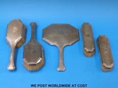 An Art Deco hallmarked silver dressing table set comprising hand mirror and four various brushes