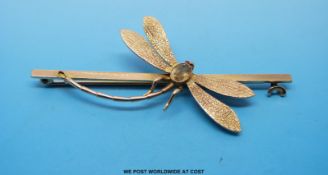 A yellow metal brooch marked 9ct gold in the form of a dragonfly with quartz body and ruby eyes