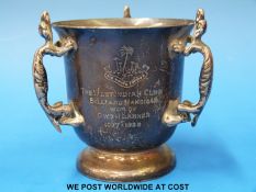 A hallmarked silver three handled loving or trophy cup with grotesque animal handles,