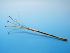 A yellow metal swizzle stick