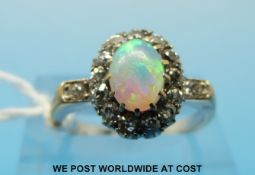 An 18ct gold ring set with an opal surrounded by diamonds (size N)