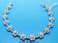 An 18ct white gold bracelet set with 14 flower clusters each comprising seven diamonds,