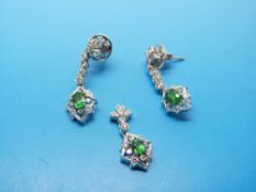 A pair of 18ct white gold earrings set with an oval tsavorite and diamonds to each and a matching