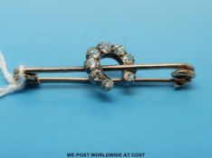 A gold brooch set with old cut diamonds in a crescent shape