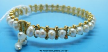 A yellow metal bangle set with 32 blister pearls,