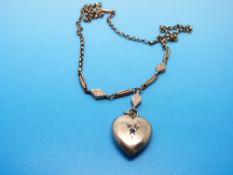 A 9ct gold Edwardian pendant in the shape of a heart on an unusual 9ct gold chain