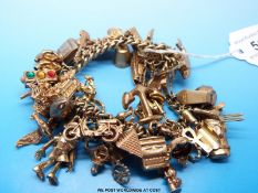 A 9ct gold charm bracelet with approximately 47 charms,