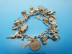 A silver charm bracelet with 27 charms (61.